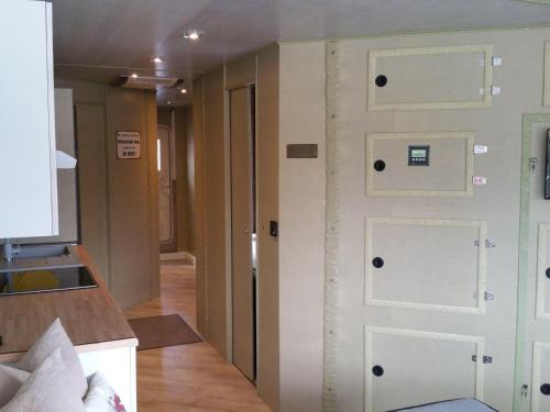 una camera con porta bianca e una cucina di Traumhaus-auf-dem-Wasser-Modernisiertes-Hausboot-13-x-4-m a Kützkow