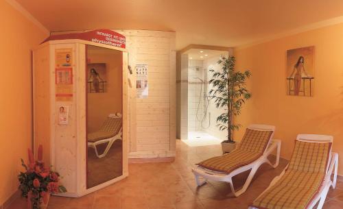 a room with two chairs and a walk in shower at Best Western Plus Schwarzwald Residenz in Triberg
