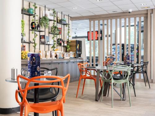 a restaurant with a table and chairs in a room at ibis Paris Alesia Montparnasse in Paris