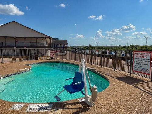 a swimming pool with a blue chair in it at Studio 6 Suites Mesquite, TX – Gross Rd. in Mesquite