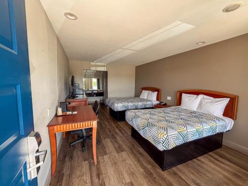 a hotel room with two beds and a desk at Studio 6 Suites Mesquite, TX – Gross Rd. in Mesquite