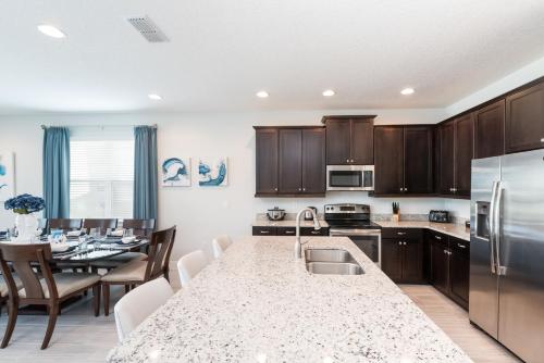 a kitchen with a large island in a kitchen with a table at Splendid Home With Private Pool, Loft Area, Waterpark & Resort Access Near Disney At Encore Resort - 7619Br in Kissimmee