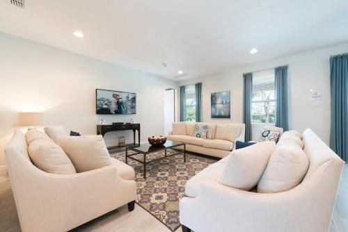a living room with white furniture and windows at Splendid Home With Private Pool, Loft Area, Waterpark & Resort Access Near Disney At Encore Resort - 7619Br in Kissimmee