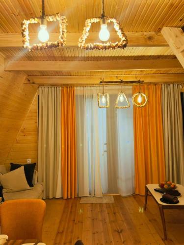 a living room with curtains and a couch and a table at Rakushki's house 2 in K'obulet'i