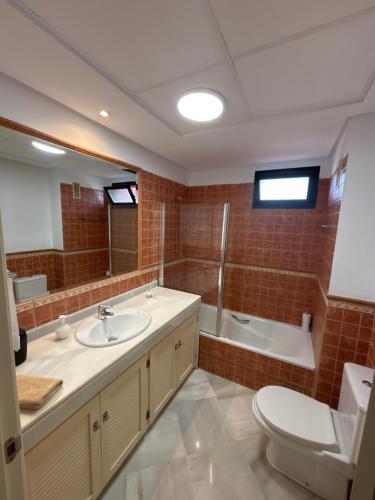 a bathroom with a toilet and a sink and a tub at Las Colinas Beach in Manilva