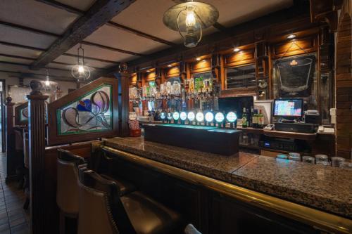 a bar in a pub with a counter and chairs at Dooly's Hotel in Birr