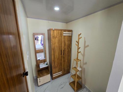 a bathroom with a wooden cabinet and a mirror at Woodlyn Homestay & Boating in Munroe Island