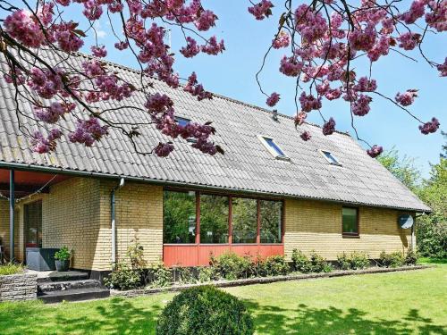 a house with a red door and purple flowers at 4 person holiday home in Nexø in Balke