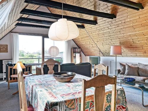 a dining room with a table and a living room at 4 person holiday home in Nexø in Balke