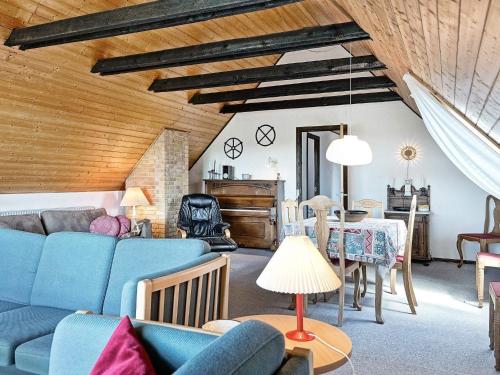 a living room with a blue couch and a table at 4 person holiday home in Nexø in Balke