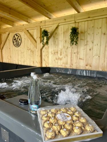 a hot tub with a tray of food and a bottle of water at MK Premium Apartamenty in Tylicz