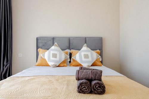 a bed with orange and white pillows on it at Красивые новые апартаменты in Astana