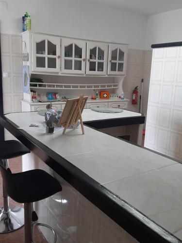 a kitchen with a counter with two chairs on it at Casa vicente in Santa Cruz das Flores