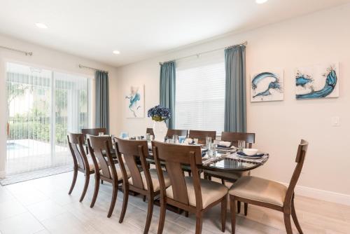 a dining room with a table and chairs at Splendid Home With Private Pool, Loft Area, Waterpark & Resort Access Near Disney At Encore Resort - 7619Br in Kissimmee