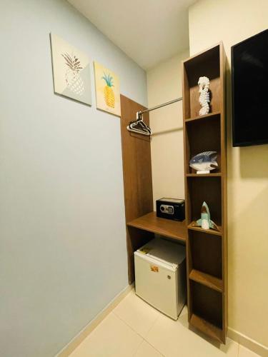 a room with a tv and a book shelf at Summer House Inn San Andres in San Andrés