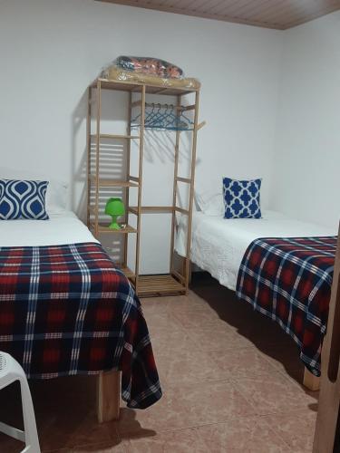 a room with two beds and a shelving unit at Casa vicente in Santa Cruz das Flores