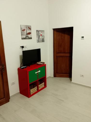a red and green cabinet with a television on it at Casa Ilaria in Gavorrano