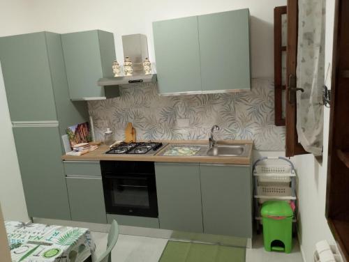 a small kitchen with white cabinets and a sink at Casa Ilaria in Gavorrano