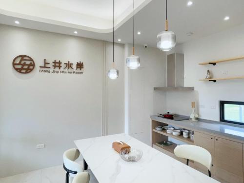 a kitchen with a white table and chairs at Shangjing Waterfront Hotel in Dongshan