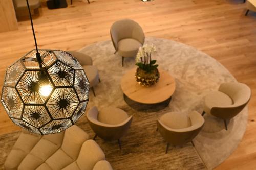 an overhead view of a living room with a table and chairs at Tratterhof Mountain Sky Hotel in Maranza