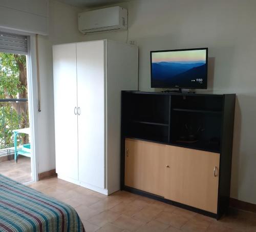 a bedroom with a flat screen tv on a cabinet at Hospedaje Libres Lodge - Apart Hotel en Paso de los Libres in Paso de los Libres