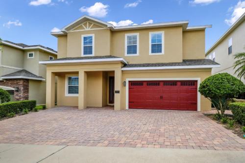 a house with a red garage at Glorious Home Near Disney With Game Room, Themed Rooms, Waterpark & Resort Access At Encore Resorts Reunion - 7643Wi in Kissimmee