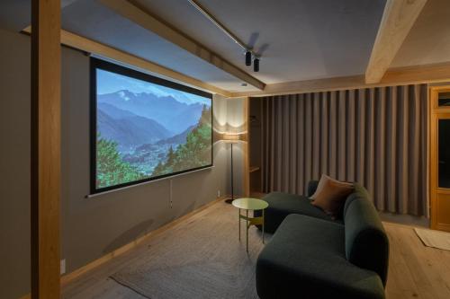 a living room with a large projection screen on the wall at YAMO Nagiso in Nagiso