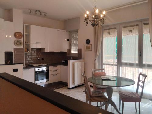 a kitchen with a table and chairs and a dining room at Appartamento silenzioso comodo alle spiagge e stazione ferroviaria in Lavagna