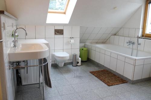 ein Badezimmer mit einem Waschbecken, einer Badewanne und einem WC in der Unterkunft Apartment Dachgalerie in München