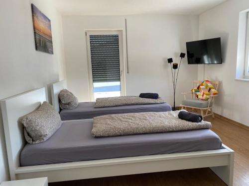 three beds sitting in a room with a tv at Velburger Ferienhaus 23 in Velburg