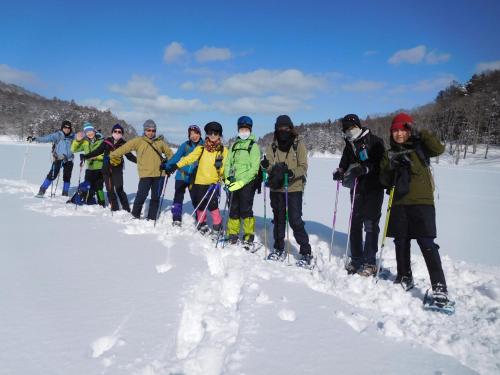 a group of people standing in the snow at Pension Pure in Iiyama