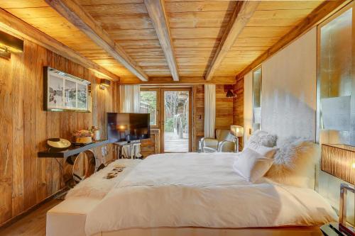 a bedroom with a large bed and a television at Megeve Luxury Estate The Royal Alpine Retreat with Mont Blanc View in Demi-Quartier