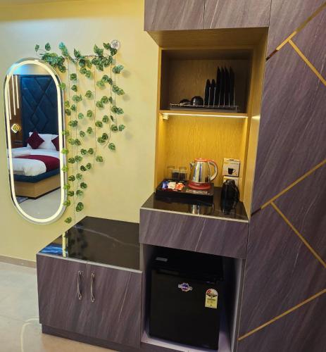 a small kitchen with a counter and a mirror at The Elite Ohana in Lucknow