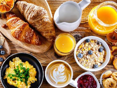 a table topped with breakfast foods and coffee and croissants at Golden Bay Galapagos in Puerto Baquerizo Moreno