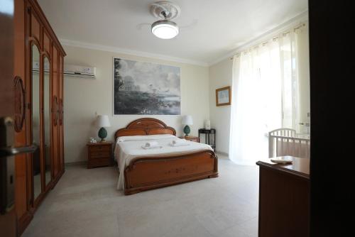 Un dormitorio con una cama y un cuadro en la pared. en Villamodica a family villa 20 min from the beach, en Módica