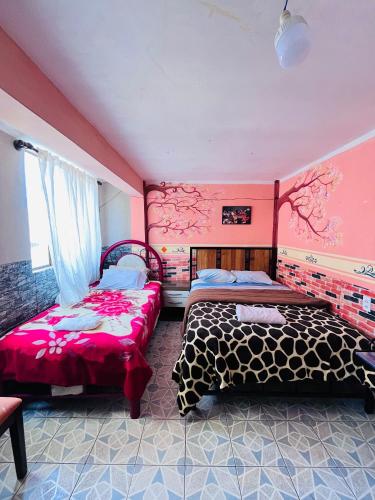 two beds in a room with pink walls at Backpacker hostal oruro in Oruro