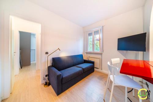 a living room with a blue couch and a desk at Il Nido Urbano - Volturno in Udine