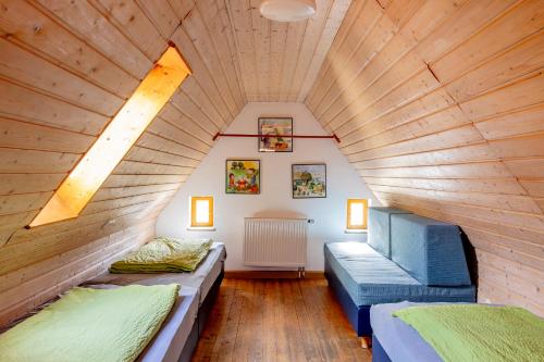 Dos camas en una habitación con techo de madera. en Ferienbauernhof Ohr, en Colmberg