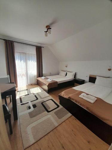 een hotelkamer met twee bedden en een bureau bij Casa Eldorado in Sovata