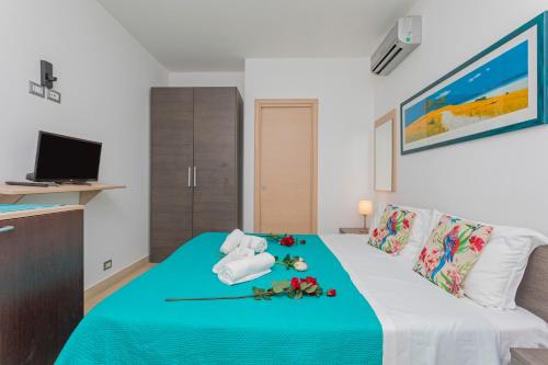 a hotel room with a bed with flowers on it at Sirina Tao Beach in Taormina