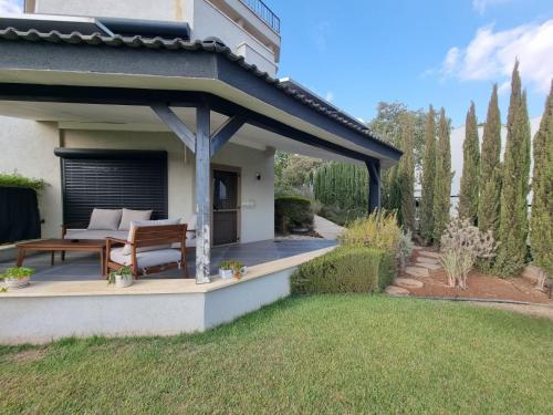 a pavilion with a bench and a table in a yard at Reimond's place - Nahal Hilazon נחל חילזון in Karmiel