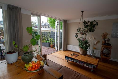 a living room with a bowl of fruit on a wooden floor at Huize Zonnebloem in Beverwijk