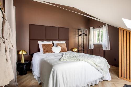 Un dormitorio con una cama grande con paredes marrones. en Suite Choco Love and SPA, en Belfort