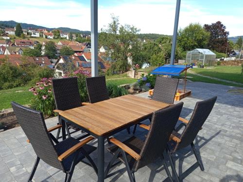 a wooden table and chairs on a patio at FeWo Wildflecken - Ferienwohnung Rhön Neubau 2021 in Wildflecken