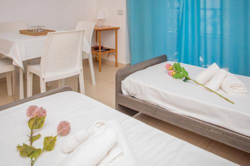 two beds in a room with towels and a table at Sirina Tao Beach in Taormina