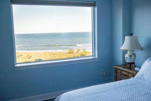 una camera da letto con finestra con vista sull'oceano di 80 Surfview Drive - Unit 604 a Palm Coast
