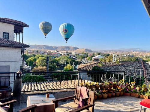 two hot air balloons are flying over a city at Sofa Hotel in Avanos