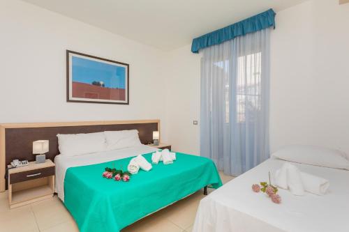 a hotel room with two beds and a window at Sirina Tao Beach in Taormina