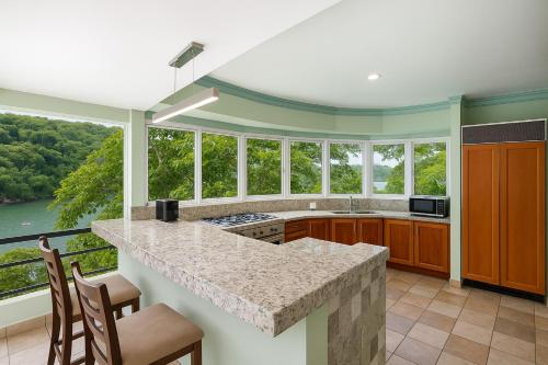 a kitchen with a large counter with chairs and windows at P V near Colomitos Beach Boutique Hotel in Puerto Vallarta