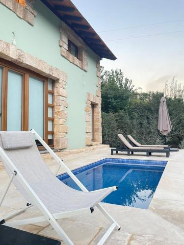 a pair of chairs sitting next to a swimming pool at Riverside Jahliye, Chouf in Al Jāhilīyah